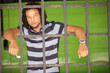 Man posing behind bars