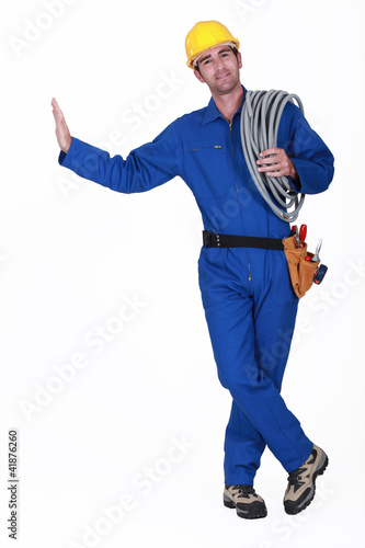 Photo: Electrician carrying spool of cable Electrician carrying spool of cable