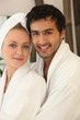 portrait of young couple all smiles wearing bathrobe