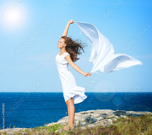 Foto: Freedom Concept. Girl with White Scarf standing on the Rock Freedom Concept. Girl with White Scarf standing on the Rock