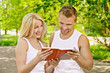 Photo: smiling couple dressed in white reading book smiling couple dressed in white reading book