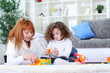 mother and girl playing on living room floor mother and girl playing on living room floor