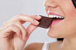 woman is biting slice of the chocolate woman is biting slice of the chocolate