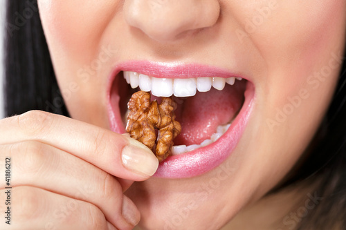 Photo: Female mouth with nut Female mouth with nut