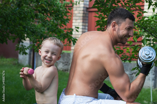 Photo: Father and son train with dumbbells Father and son train with dumbbells