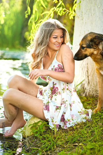 Photo: Happy and attractive teen girl playing with dogs in green field Happy and attractive teen girl playing with dogs in green field