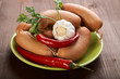 Sausages with spices and vegetables on an wooden table Sausages with spices and vegetables on an wooden table