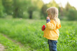 Adorable baby blow soap bubbles in park