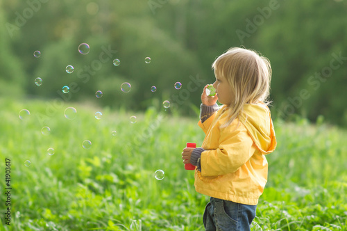 Photo: Adorable baby blow soap bubbles in park Adorable baby blow soap bubbles in park