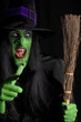 Witch and her broom stick, black background.