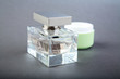 bottle of perfume and tube of a cosmetic cream on grey bottle of perfume and tube of a cosmetic cream on grey