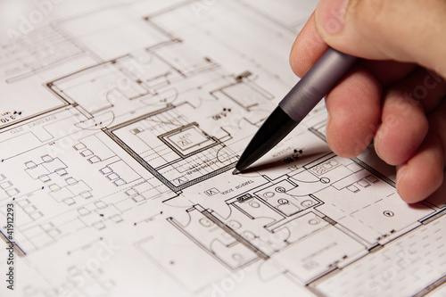 Photo: Pencil in hand on building plans Pencil in hand on building plans