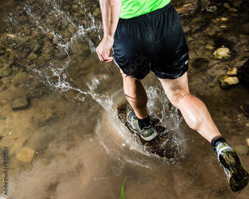 Photo: Jogger durchquert einen Bach Jogger durchquert einen Bach