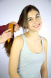 Hairdresser brushing long hair of female model