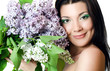 Beautiful woman with spring flowers of a lilac. Skincare