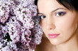 Beautiful woman with spring flowers of a lilac. Skincare
