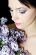Beautiful woman with spring flowers of a lilac. Skincare