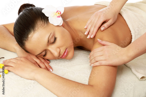Foto: A beautiful woman getting massage in a spa center A beautiful woman getting massage in a spa center