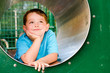 Cute young child boy or kid playing in tunnel on playground.