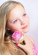 Beautiful young girl with a pink rose
