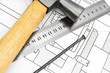 Hammer, ruler and nail on the drawing.