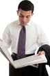 Photo: Businessman reading stocks and shares prices in newspaper Businessman reading stocks and shares prices in newspaper