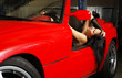 Woman resting in the red car.