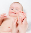 Mother massaging her baby girl