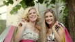 Two happy young women smiling with shopping bags