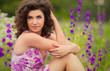 Beautiful young woman in purple flowers outdoors