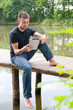 Photo: Mann entspannt am See sitzend, mit tablet pc Mann entspannt am See sitzend, mit tablet pc