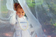 Photo: little girl hiding face behind transparent tissue in garden little girl hiding face behind transparent tissue in garden