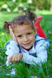 cute little girl lying on green grass