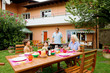 Photo: Family having a barbecue in the garden, eating Family having a barbecue in the garden, eating