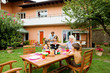 Photo: Family having a barbecue in the garden, eating Family having a barbecue in the garden, eating