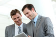 Business partners working in hallway with electronic tablet