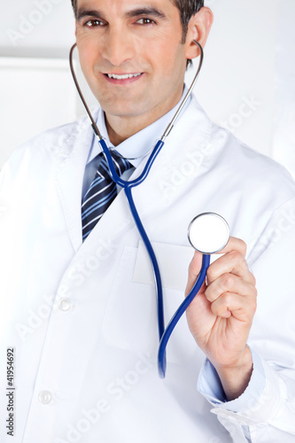 Photo: Male Doctor Holding Stethoscope Male Doctor Holding Stethoscope