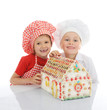 Happy kids cooking gingerbread house
