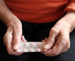 Close up of old hands with tablets.
