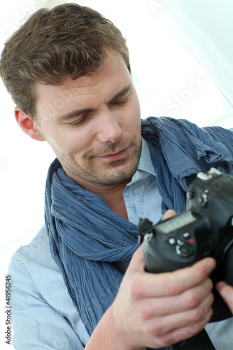 Photo: Handsome guy holding photo camera Handsome guy holding photo camera