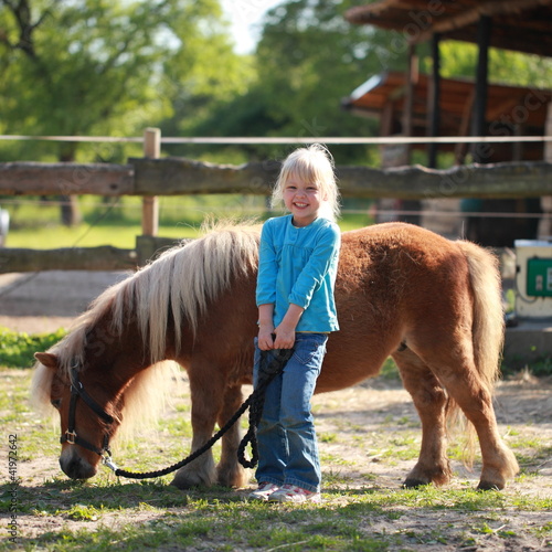 Photo: kleines Mädchen mit einem Pony kleines Mädchen mit einem Pony