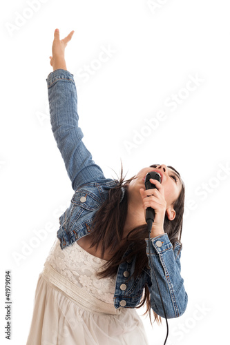 Photo: Preteen girl singing with microphone isolated on white Preteen girl singing with microphone isolated on white