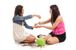Photo: Preteen and teen sisters with piggybank isolated on white Preteen and teen sisters with piggybank isolated on white