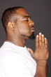 Young man holding his hands in prayer.