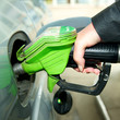 Frau tankt Auto an Tankstelle