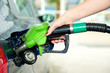 Frau tankt Auto an Tankstelle