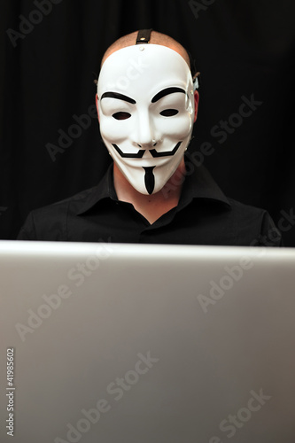 Photo: member of Anonymous hacker group at computer member of Anonymous hacker group at computer
