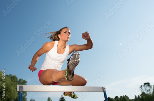 Photo: Professional female hurdler in action Professional female hurdler in action