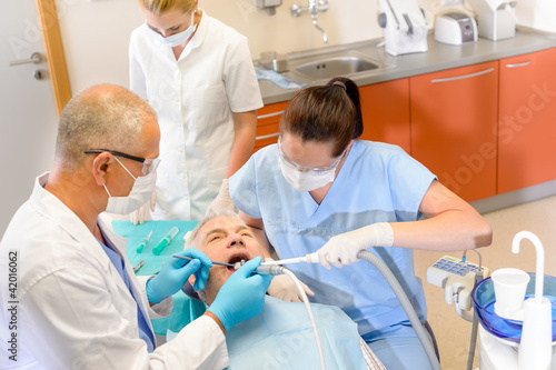 Photo: Dentist with nurses doing surgery on patient Dentist with nurses doing surgery on patient