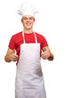 portrait of young cook man doing success symbol against a white